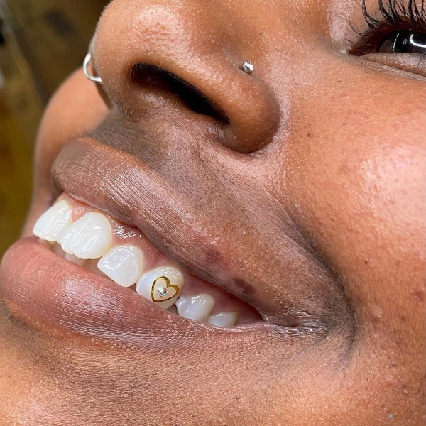 A close up of a person with a piercing on their teeth