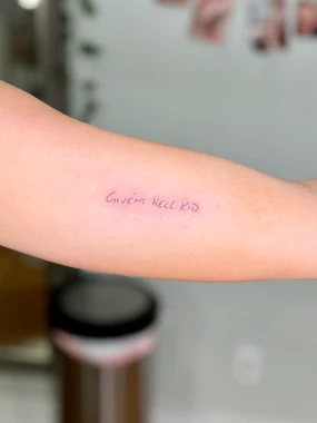A person with their arm tattoo is holding it.
