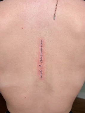 A person with a back tattoo has been stitched.