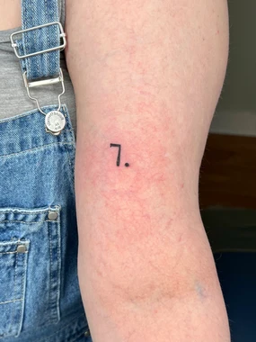 A person with a number seven tattoo on their arm.