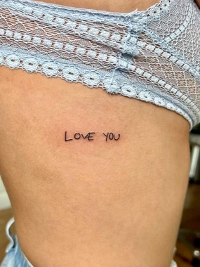 A person with their leg in shorts and a tattoo that says " love you ".