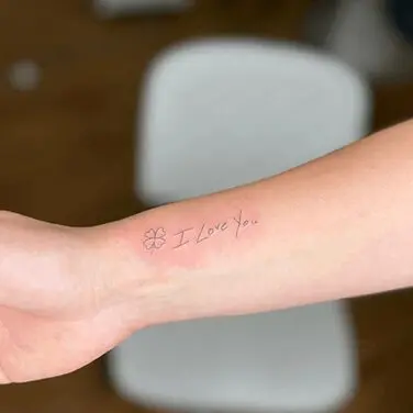 A person with their arm tattoo is holding it.