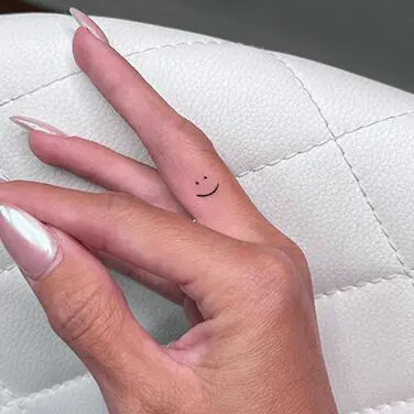 A woman 's hand with a small tattoo on it.